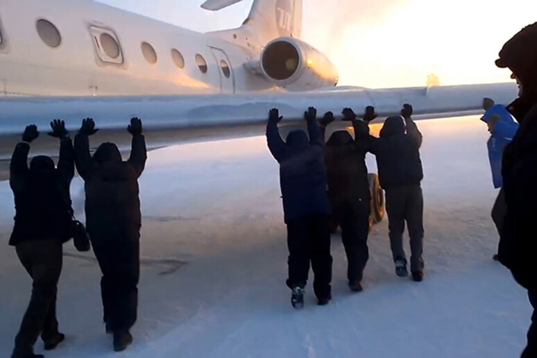 Passeggeri spingono l 'aereo per sbloccare il carrello congelato, foto tratta dal sito LifeNews - RIPRODUZIONE RISERVATA
