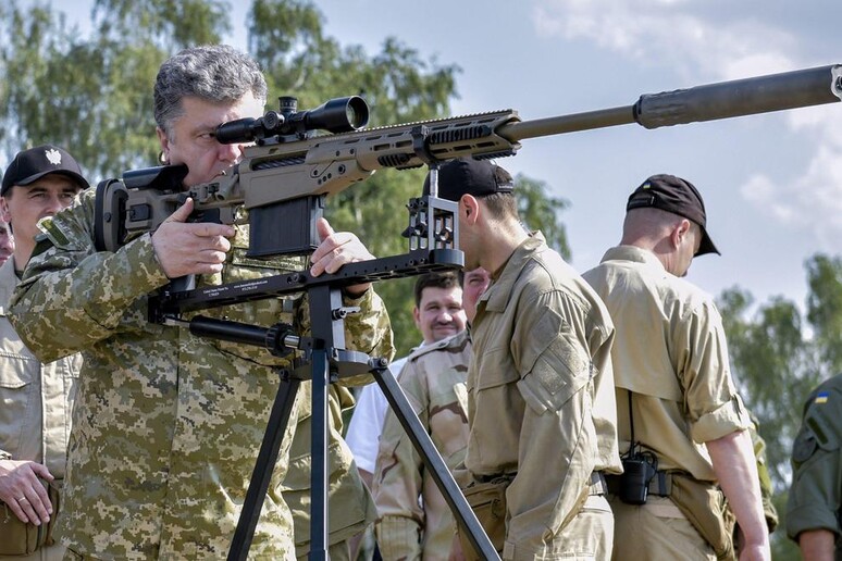 Il presidente ucraino, Petro Poroshenko, ispeziona un fucile di precisione delle forze armate di Kiev - RIPRODUZIONE RISERVATA