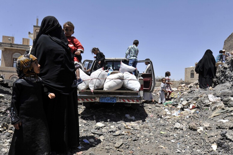 Una donna con i suoi bambini in una strada di Sanaa © ANSA/EPA