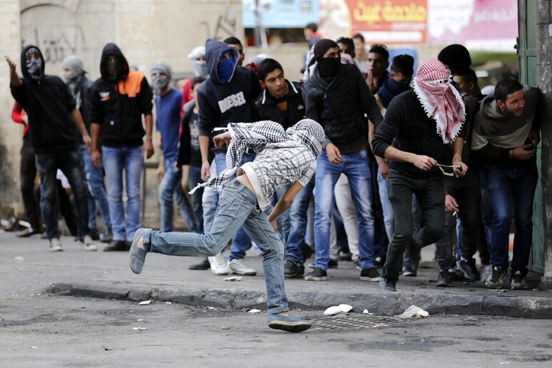 Dimostranti palestinesi lanciano pietre a Hebron lo scorso 27 ottobre © ANSA/EPA
