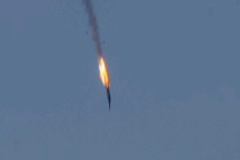Una foto tratta da un video fornito dalla tv HaberTurk mostra il jet militare russo mentre precipita dopo essere stato colpito da caccia turchi sopra la Siria nella zona di confine con la Turchia © ANSA/EPA