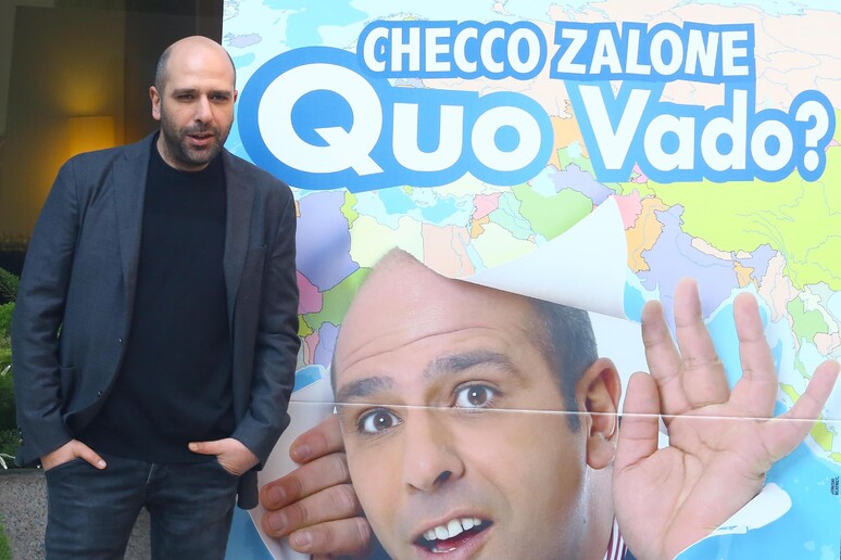 Checco Zalone davanti al manifesto di Quo vado - RIPRODUZIONE RISERVATA