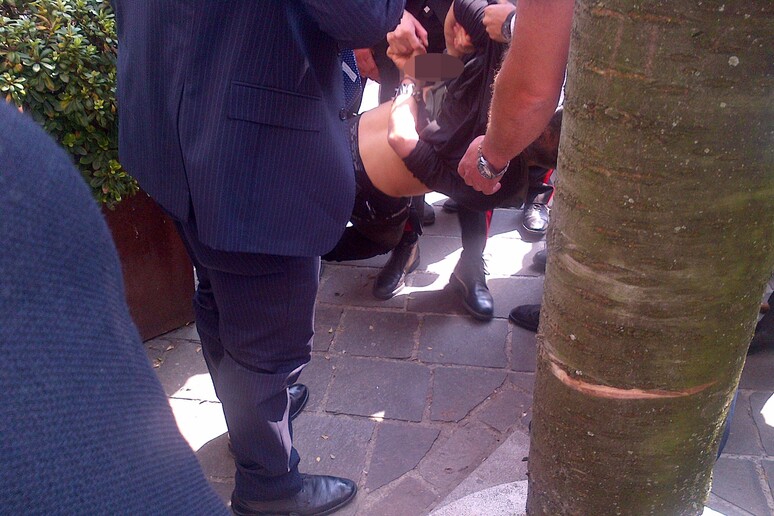 L 'uomo bloccato dalle forze dell 'ordine a Saronno, dove era in corso un comizio di Silvio Berlusconi - RIPRODUZIONE RISERVATA