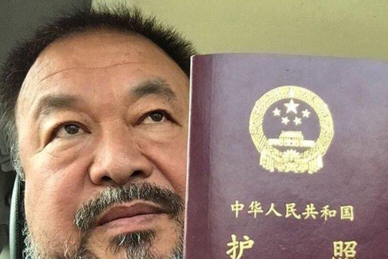 L 'artista cinese Ai Weiwei mostra il passaporto restituitogli recentemente - RIPRODUZIONE RISERVATA
