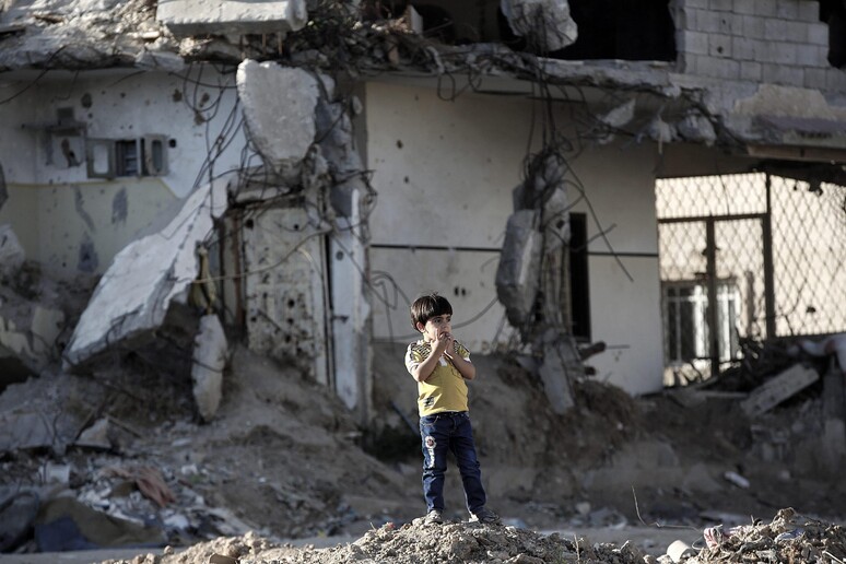 Un bambino tra le case distrutte dalla guerra a Gaza - Primopiano - Ansa.it
