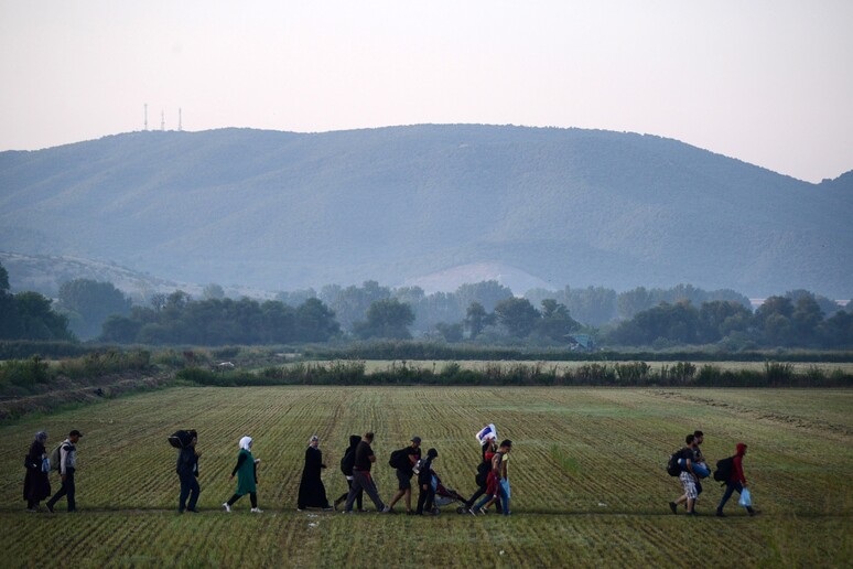 Immigrati in viaggio dalla Grecia verso la Macedonia © ANSA/AP