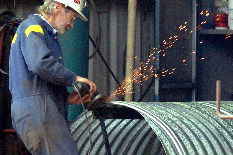 Un operaio metalmeccanico al lavoro in un 'officina in una foto d 'archivio - RIPRODUZIONE RISERVATA