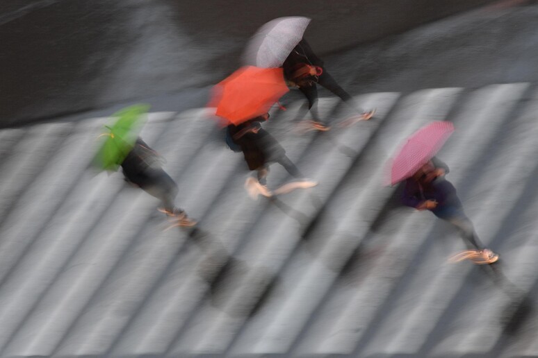 Persone camminano sotto la pioggia, Genova - RIPRODUZIONE RISERVATA
