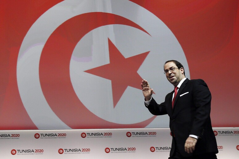Il premier tunisino Youssef Chahed saluta i giornalisti a conclusione della conferenza  'Tunisia 2020 ' © ANSA/EPA