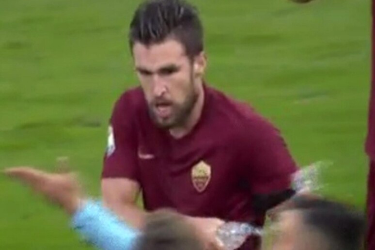 In un fermo immagine il centrocampista della Roma Kevin Strootman tira l 'acqua al centrocampista  della Lazio in panchina Danilo Cataldi - RIPRODUZIONE RISERVATA