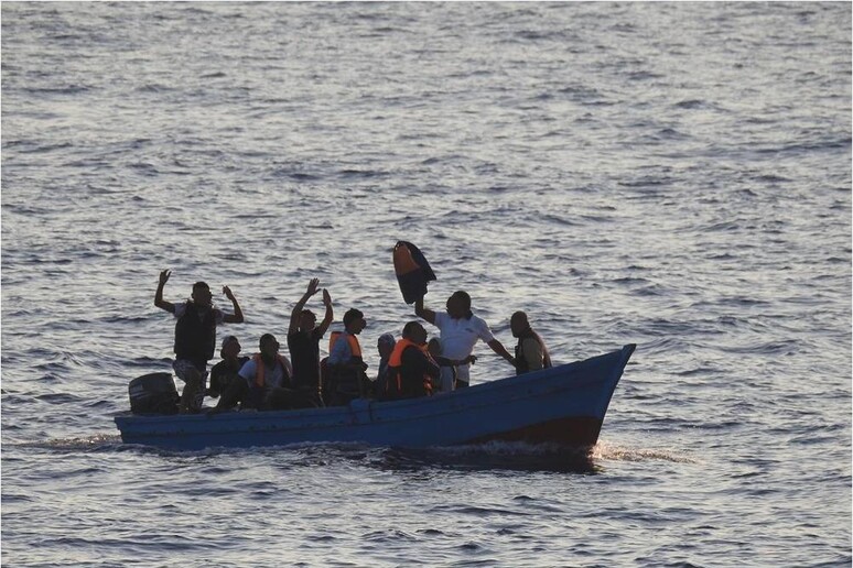 Migranti a bordo di un 'imbarcazione nel Mediterraneo - RIPRODUZIONE RISERVATA