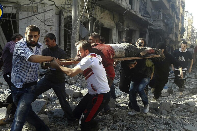 Civili evacuano una vittima dopo i bombardamenti governativi sulla parte orientale di Aleppo controllata dai ribelli (foto fornita del gruppo di difesa civile conosciuto come i Caschi bianchi) © ANSA/AP