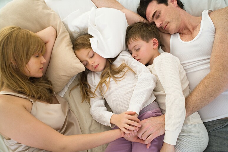 Genitori e figli insieme nel letto matrimoniale. Image Source iStock. - RIPRODUZIONE RISERVATA