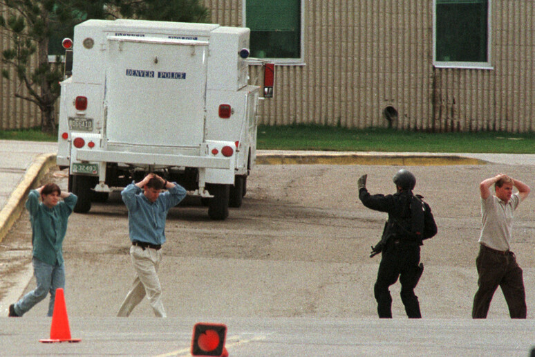 La strage alla Columbine High School, gli studenti vengono portati fuori dall 'edificio scolastico sotto scorta dagli agenti - RIPRODUZIONE RISERVATA