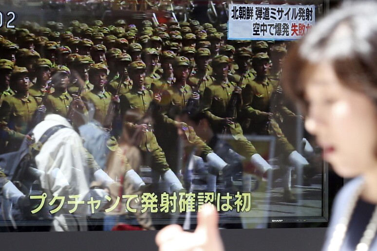 Tokyo, una donna passa davanti a uno schermo tv che mostra le truppe di Pyongyang © ANSA/AP