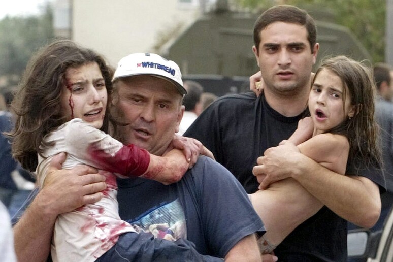 Bambini e adulti dopo assedio nella scuola di Beslan nel 2004 - RIPRODUZIONE RISERVATA