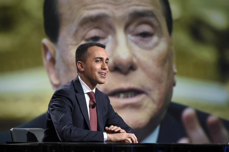 Di Maio con Berlusconi sullo sfondo - RIPRODUZIONE RISERVATA