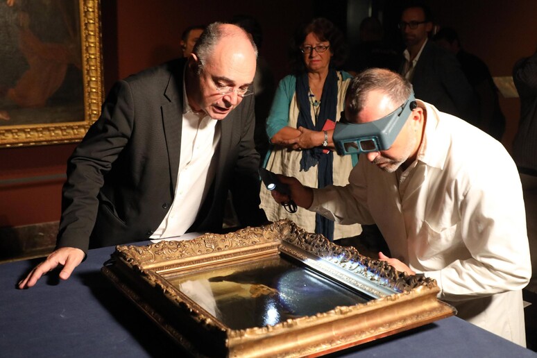 Due restauratori esaminano l 'opera "La cena dei pellegrini di Emmaus" di Rembrandt  ANSA/ MATTEO BAZZI - RIPRODUZIONE RISERVATA