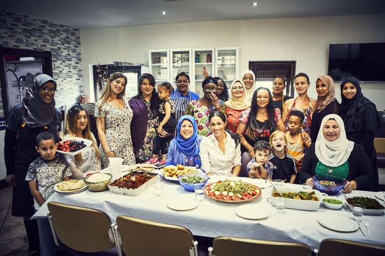 Meghan, la duchessa del Sussex, al centro, posa per una fotografia con le donne della Hubb Community Kitchen al Centro culturale musulmano Al Manaar di Londra. © ANSA/AP