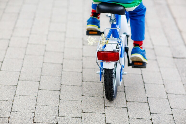 Un bambino in bicicletta - RIPRODUZIONE RISERVATA