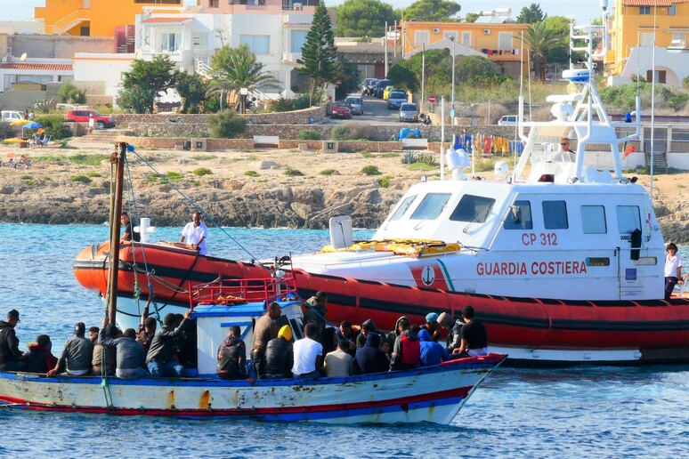 Migranti a bordo di un barcone entrano nel porto di Lampedusa. Immagine d 'archivio - RIPRODUZIONE RISERVATA