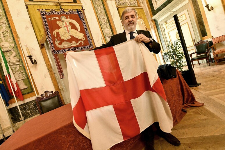 Il sindaco Bucci mostra la bandiera di Genova - RIPRODUZIONE RISERVATA