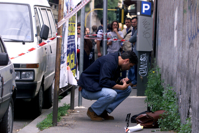 Una foto di  archivio del 20 Maggio 1999 di un inquirente che osserva la borsa di Massimo D ' Antona sul luogo del  delittto - RIPRODUZIONE RISERVATA