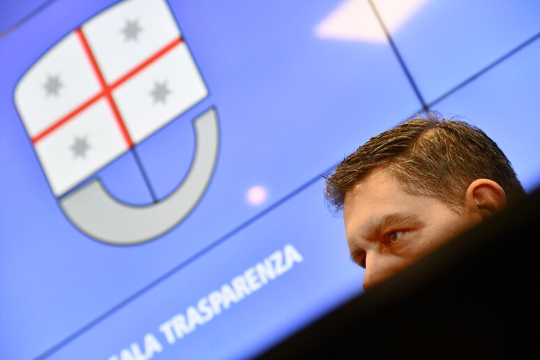 Il governatore Toti con alle spalle il simbolo della Regione Liguria - RIPRODUZIONE RISERVATA