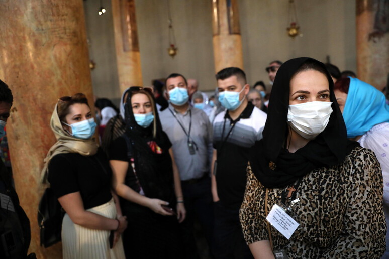 Turisti con mascherine anti-coronavirus nella Basilica della Natività a Betlemme -     RIPRODUZIONE RISERVATA