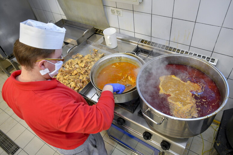 Una cuoca al lavoro © ANSA/EPA