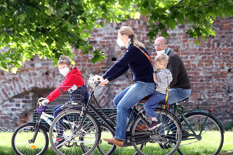 Una famiglia in bicicletta - RIPRODUZIONE RISERVATA