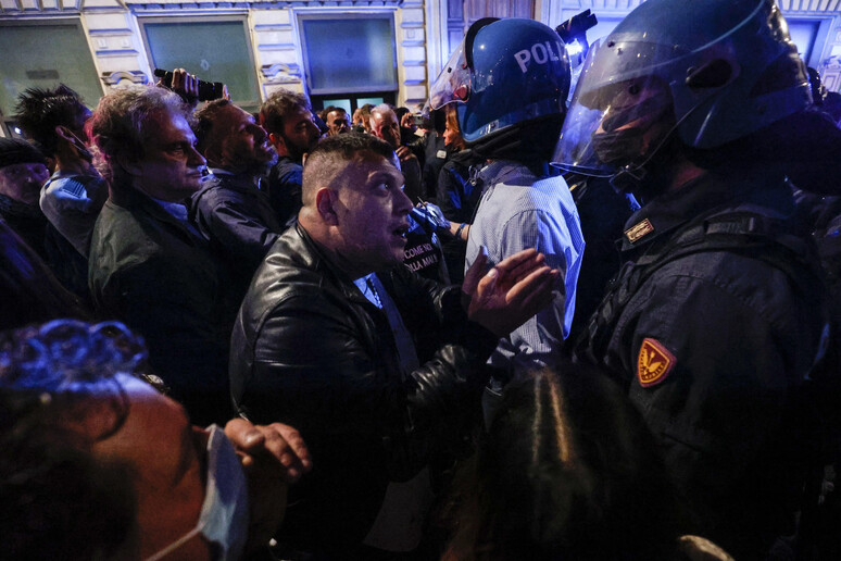 Giuliano Castellino con alcuni poliziotti durante gli scontri di sabato scorso - RIPRODUZIONE RISERVATA
