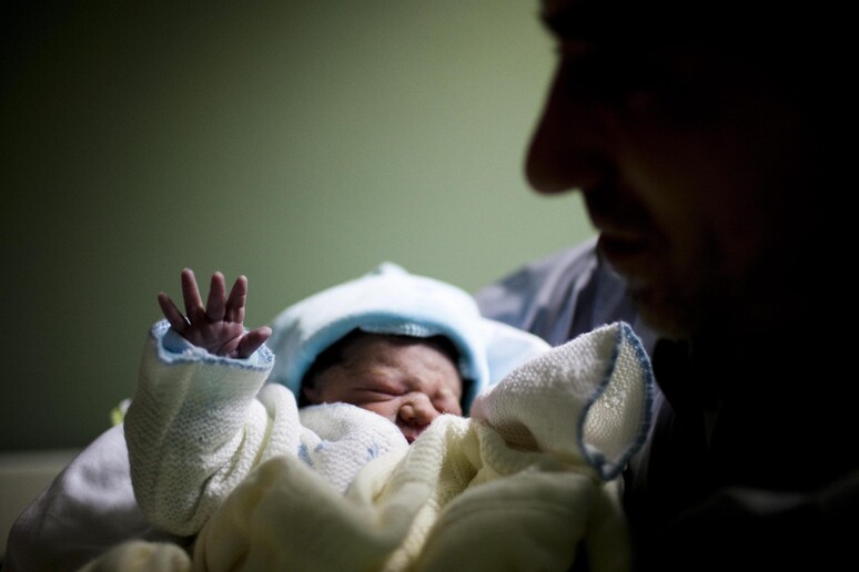 Un bambino appena nato in ospedale con il papà in una foto d 'archivio © ANSA/EPA