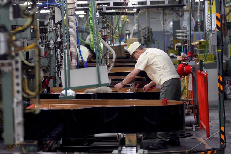 Una immagine di archivio di un operaio impegnato in una catena di montaggio all 'interno di una fabbrica - RIPRODUZIONE RISERVATA
