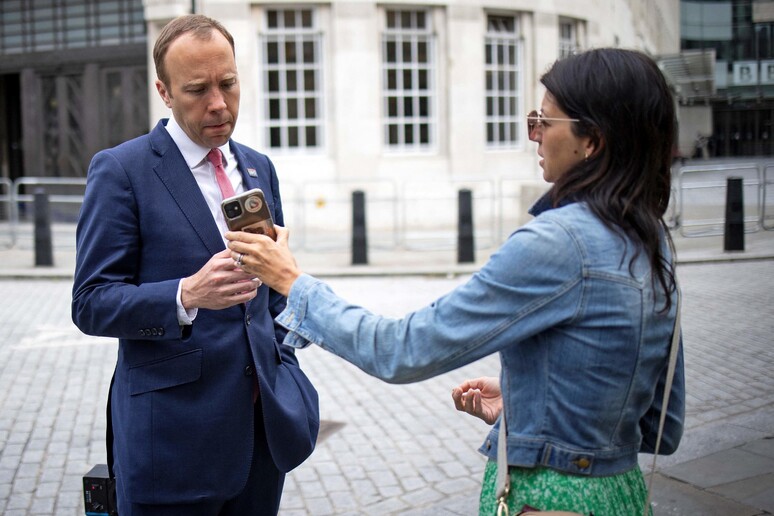 Matt Hancock guarda il telefono della sua assistente Gina Coladangelo mentre lasciano la BBC nel centro di Londra il 6 giugno 2021 Photo by Tolga Akmen / AFP © ANSA/AFP