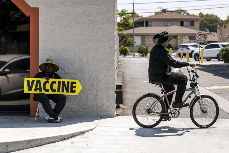 Un uomo indica un centro vaccinale a Los Angeles © ANSA/EPA