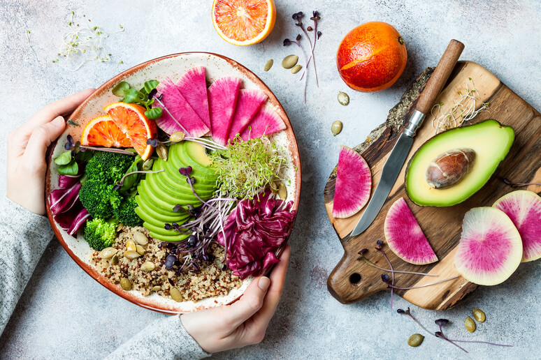 Piatto vegan con quinoa, micro greens, avocado, arancia rossa, broccoli, germogli foto iStock. - RIPRODUZIONE RISERVATA