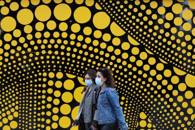 Due ragazze camminano con la mascherina © ANSA/EPA