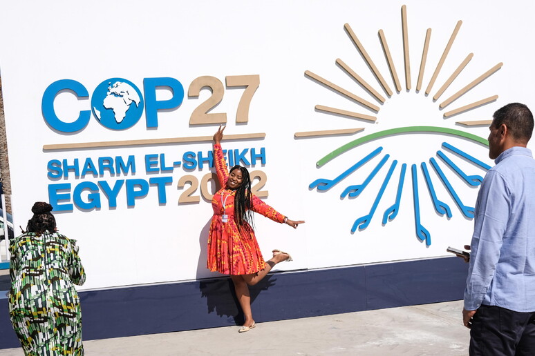 Una donna posa davanti al Centro congressi di Cop27in Sharm El-Sheikh, in Egitto, EPA/SEDAT SUNA © ANSA/EPA