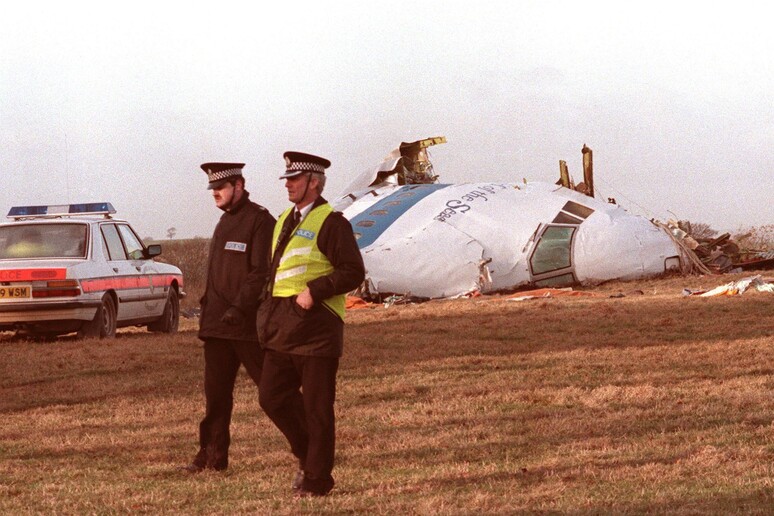 Due poliziotti il 21 dicembre 1988 passano davanti a quello che resta del Pam Am Boeing 747 - RIPRODUZIONE RISERVATA
