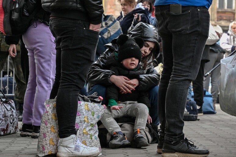 Una donna con il suo bimbo appena arrivata da Leopoli alla stazione di Przemysl in Polonia © ANSA/AFP