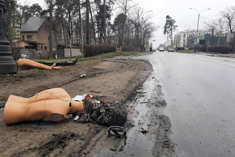 Ucraina: volontari raccolgono detriti per strada a Bucha - RIPRODUZIONE RISERVATA