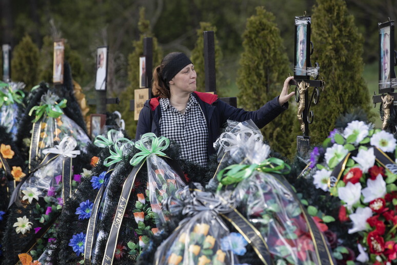 La gente piange sulle tombe di un cimitero a Irpin, Ucraina © ANSA/EPA