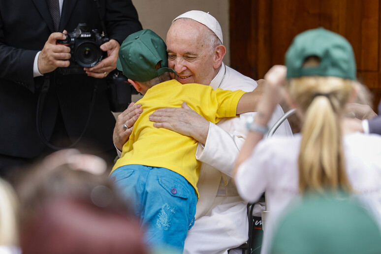 Un bambino rifugiato ucraino abbraccia il Papa - RIPRODUZIONE RISERVATA