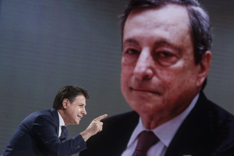 Il leader del Movimento 5 Stelle, Giuseppe Conte e dietro una foto del premier Mario Draghi - RIPRODUZIONE RISERVATA