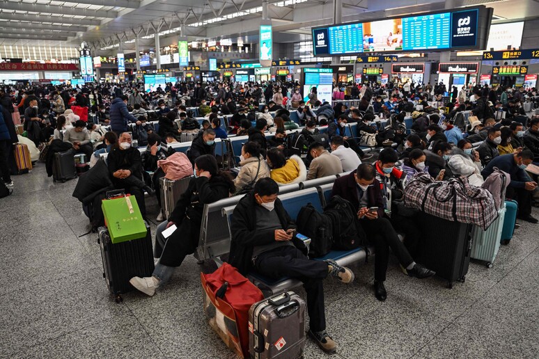 Passeggeri in attesa dei treni nella stazione di Shangai © ANSA/AFP