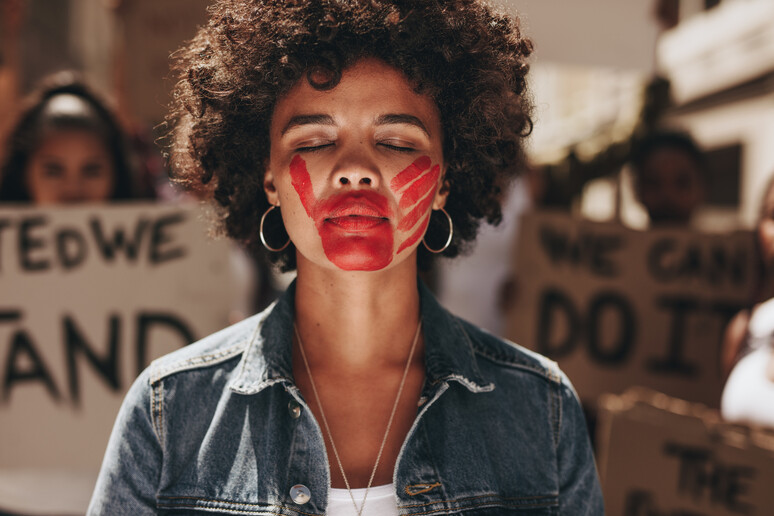 Woman protesting against domestic violence @iStock. - RIPRODUZIONE RISERVATA