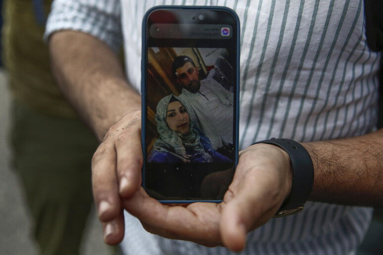 Un superstite siriano mostra sul cellulare la foto della moglie dispersa dopo il naufragio di Pylos © ANSA/EPA