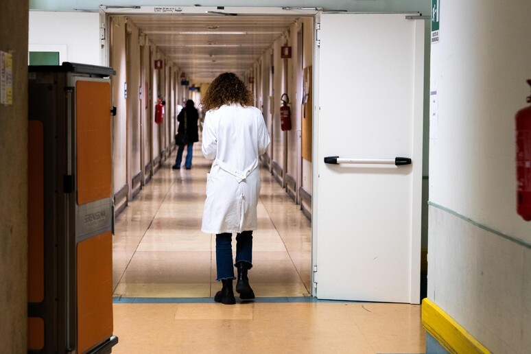Una dottoressa nei corridoi dell 'ospedale in una foto di archivio - RIPRODUZIONE RISERVATA